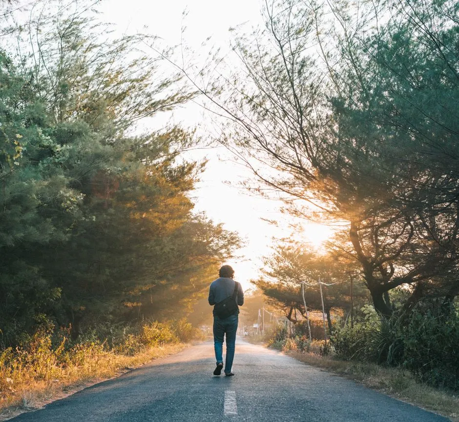 Person walking alone along a road, illustrative of the reentry process after release