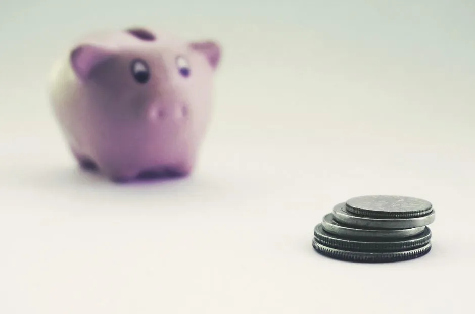 Coins beside a piggy bank, illustrative of sending money to an inmate's account